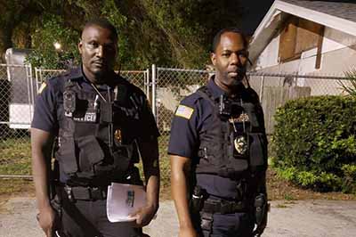 Two professional security guards in tactical gear providing security services at night in Orlando, Florida.